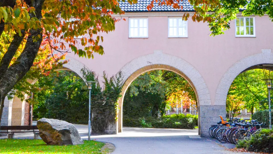 Arches beneath a pink building.