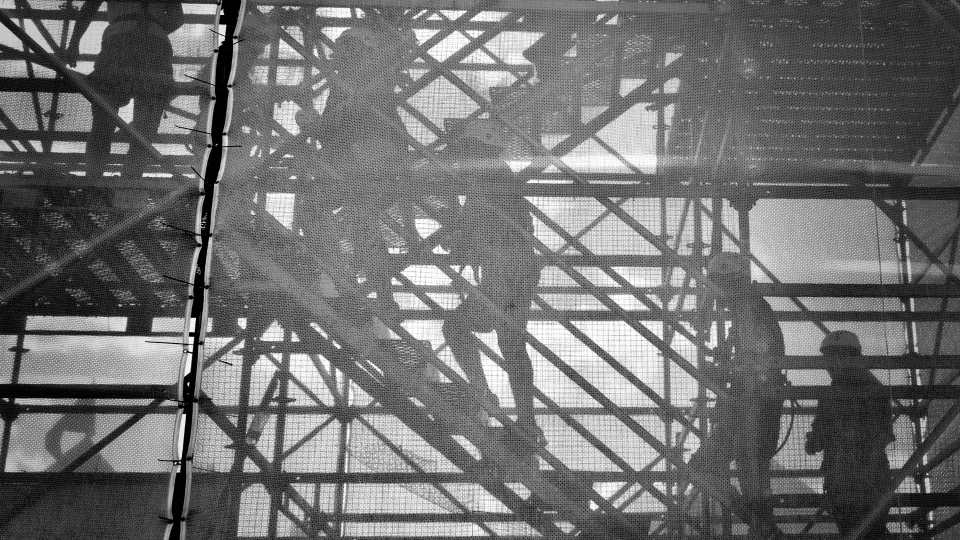 Construction workers walking up scaffolding