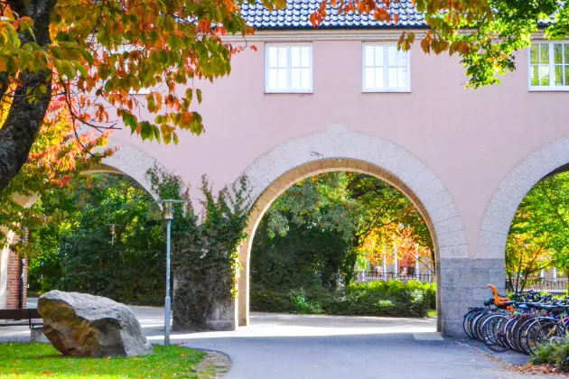 Arches beneath a pink building.