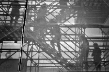 Construction workers walking up scaffolding