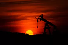 A pump-jack mining crude oil with the sunset in the background