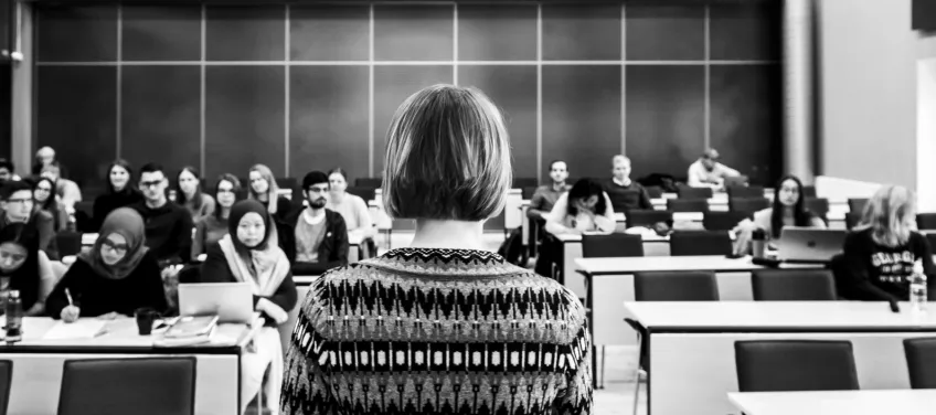 A teacher stands in front of a class of students.