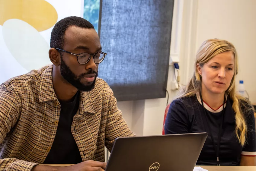 A man and a woman looking at a computer