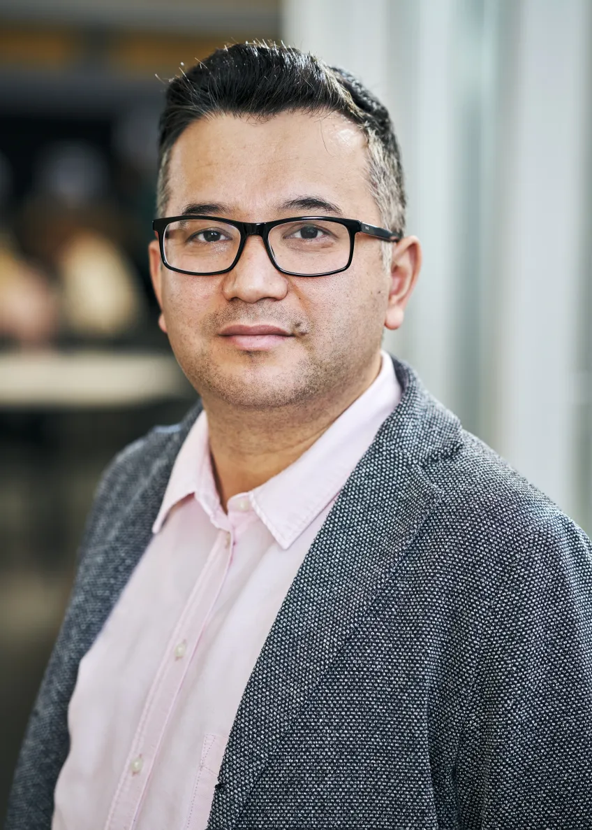Portrait photo of a person in a grey jacket.