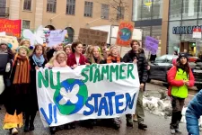 ett tjugotal ungdomar håller upp en banderoll som säger "nu stämmer vi staten"